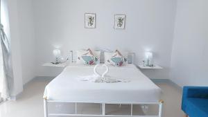 芭东海滩Cinderella Residence的白色的客房配有两张床和蓝色的沙发。