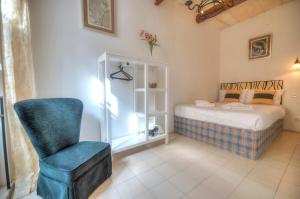 瓦莱塔Charming house in the heart of Valletta CPAC1-3的一间卧室配有一张床和一张蓝色椅子
