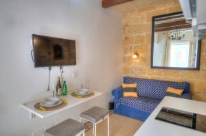瓦莱塔Charming house in the heart of Valletta CPAC1-3的客厅配有蓝色的沙发和电视