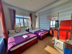 惹岛Thanh Tran Guesthouse Lý Sơn的一间卧室配有两张床和电视。