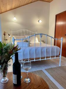 亚林加普Sienna Lodge的一间卧室配有一张床,桌子上备有一瓶葡萄酒