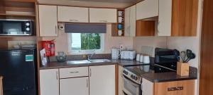 古德瑞同A5 Avocet Rise的厨房配有白色橱柜和黑色冰箱。