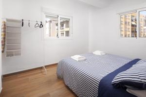 托雷德尔马尔Apartamento Torre del Mar的一间白色卧室,配有床和2个窗户