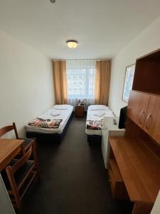 什切青Jantar Resort的客房设有两张床和一张书桌