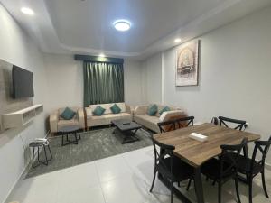 麦加ديار المشاعر للشقق المخدومة Diyar Al Mashaer For Serviced Apartments的客厅配有桌子和沙发