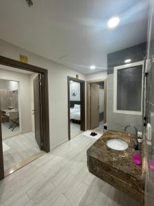 麦加ديار المشاعر للشقق المخدومة Diyar Al Mashaer For Serviced Apartments的一间带水槽的浴室和一间带卧室的房间