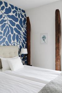维斯比Kalk Hotel的一间卧室配有一张蓝色和白色墙壁的床