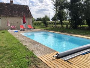 Betz-le-ChâteauVilla d'une chambre avec piscine privee jardin amenage et wifi a Betz le Chateau的一座带木甲板的游泳池,位于一座房子旁边