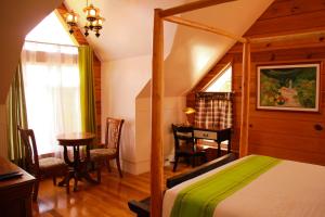 碧瑶GuestHaven Home Baguio的一间卧室配有一张床、一张桌子和一张桌子