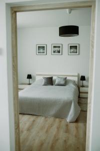 塔尔努夫Apartament Magnolia -centrum的白色卧室配有床和镜子