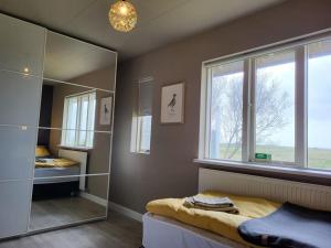 BrjansstadirSibbu Hús的一间卧室配有镜子、一张床和一个窗户
