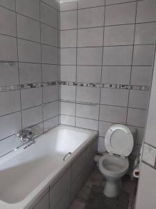 塞吉菲尔德Paradise Lake flats的白色的浴室设有浴缸和卫生间。