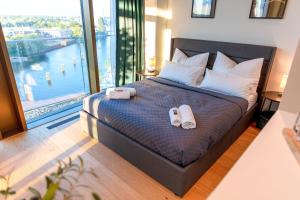奥尔登堡CABANA - TheView - 10th Floor - Terrasse - Waterfront - Hafenviertel的一间卧室配有一张床,并备有2个拖鞋