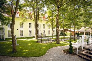 讷凡姆伊恩涅德巴Schlosshotel Neufahrn的一座大白色的建筑,在院子里种有树木