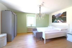 费尔德基希Montfort Apartments - Feldkirch的卧室配有白色的床和吊灯。