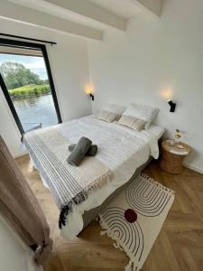 蒙尼肯丹Surla Houseboat De Saek with tender的一间卧室设有一张大床和大窗户