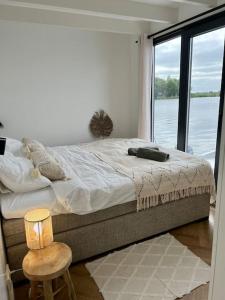蒙尼肯丹Surla Houseboat De Saek with tender的一间卧室设有一张大床,享有水景