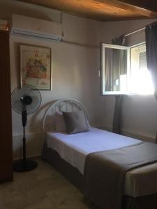 库萨达斯Villa Anja的一间卧室配有一张带风扇和窗户的床。