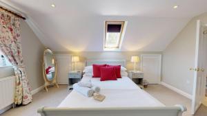 巴拉顿Spring Hill Cottage的卧室配有带红色枕头的大型白色床