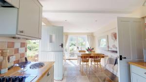 巴拉顿Spring Hill Cottage的厨房配有白色橱柜和桌椅