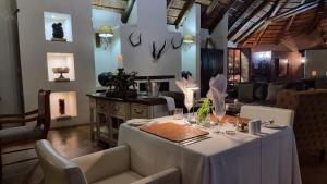 法尔瓦特Bushwa Private Game Lodge的一间配备有白色桌椅的用餐室