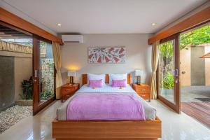 海神庙Nyanyi Sanctuary Villa by Ini Vie Hospitality的卧室配有一张带粉红色枕头的大床