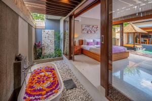 海神庙Nyanyi Sanctuary Villa by Ini Vie Hospitality的一间带浴缸和床的卧室以及一个游泳池