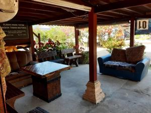 甲抛峇底Homestay Teratak Kayu kota Aur的一个带顶棚、沙发和桌子的庭院