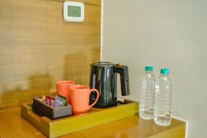 古尔冈古茹格拉姆市中心万怡酒店的一个带咖啡壶和两瓶水的托盘