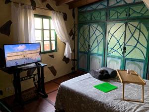 圣克鲁斯-德特内里费CASA RURAL CANARIA HOMBRE DE PALO的一间卧室,卧室内配有电脑,卧室配有一张床和一个窗户