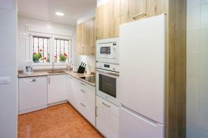 LezaZaldivar etxea的厨房配有白色橱柜和白色冰箱。