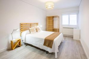 LezaZaldivar etxea的卧室配有一张白色大床和木制床头板
