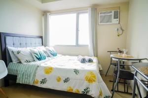 卡加盐德奥罗Urban Oasis Condo Near Ayala Centrio的一间卧室配有一张床、一张桌子和一个窗户。