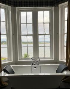 ArdrishaigThe Grey Gull Hotel的窗户客房内的白色大浴缸