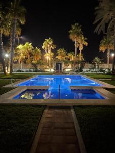 卡莱塔德贝莱斯MAGNIFICO CHALET UNICO JUNTO AL MAR CALETA DE VELEZ的棕榈树的蓝色游泳池