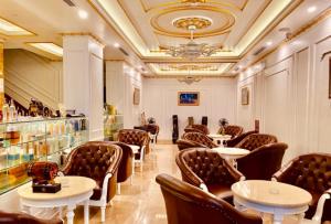 北宁Gold Business Hotel Bắc Ninh的一间在房间内配有桌椅的餐厅
