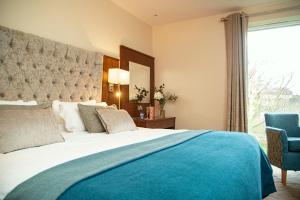 韦斯特波特怀亚特酒店的一间卧室配有一张大床和一张蓝色椅子