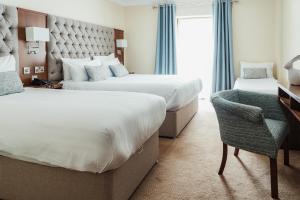 韦斯特波特怀亚特酒店的酒店客房 - 带两张床、一张桌子和一把椅子