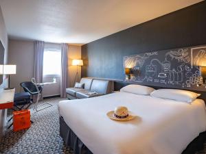 沙托贝尔纳尔科納克宜必思尚品酒店的酒店客房设有一张大床,上面有帽子