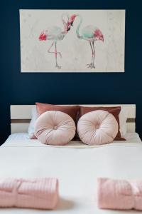 弗罗茨瓦夫Nice Apartment - Near Sky Tower - Private Parking的一张带粉红色枕头的床和鸟儿绘画