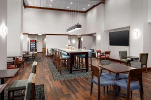 玛丽湖Hampton Inn & Suites at Lake Mary Colonial Townpark的用餐室配有桌椅和平面电视。