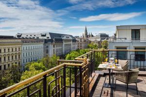 维也纳维也纳广场希尔顿酒店的市景阳台配有桌椅。