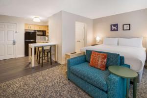 安多弗Sonesta ES Suites Andover Boston的酒店客房,配有床和蓝色的沙发