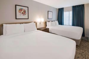 安多弗Sonesta ES Suites Andover Boston的酒店客房设有两张床和窗户。