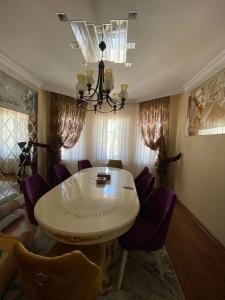 巴库Baku, Shagan Villa的一间设有白色桌子和紫色椅子的用餐室