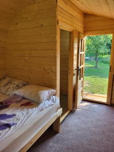 MesenteaCristel Căsuța Fără Gânduri的小木屋内的卧室,配有一张床