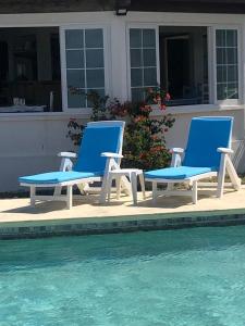 马埃堡CHILLpill Guest House的两把蓝色椅子坐在游泳池旁