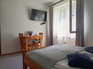 韦特利纳Mala Chatka的一间卧室配有一张床、一张书桌和一台电视