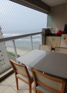 伊塔尼亚恩Resort Itanhaém - Pé na areia的一个带桌椅和大窗户的厨房