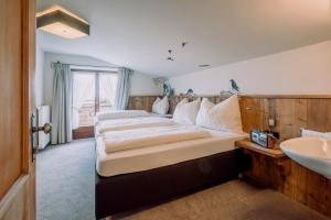 瑟尔Alpengasthof Hochsöll的一间卧室设有两张床和盥洗盆